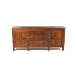 An Albert Owlman Harrison oak dining room suite for ten, comprising sideboard, large dining table