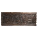 A CARVED WALNUT PANEL 16TH CENTURY decorated with a central urn of flowers flanked by cypress trees,