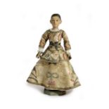 AN ITALIAN CARVED WOOD DOLL 19TH CENTURY with glass eyes, the painted wooden head and body with