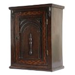AN OAK AND MARQUETRY INLAID SPICE CUPBOARD EARLY 18TH CENTURY AND LATER the panelled door with