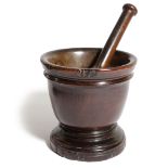 A TREEN LIGNUM VITAE MORTAR 18TH CENTURY the moulded rim above a short moulded stem and stepped