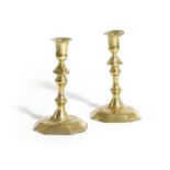 A PAIR OF GEORGE II BRASS CANDLESTICKS MID-18TH CENTURY each with fixed sconces, a multi-knopped