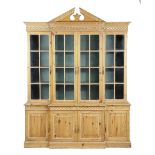 A PINE BREAKFRONT BOOKCASE IN GEORGE II STYLE 20TH CENTURY with an architectural pediment and