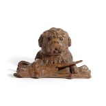 A BLACK FOREST CARVED LINDENWOOD TERRIER INKWELL LATE 19TH CENTURY modelled with the dog's paw on