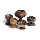 FIVE TREEN SALTS 19TH CENTURY AND LATER in lignum vitae, boxwood and fruitwood, with turned