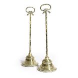 A PAIR OF VICTORIAN BRASS DOORSTOPS MID-19TH CENTURY each with rope twist handles, above semi-