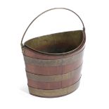 A MAHOGANY AND BRASS BOUND PEAT BUCKET EARLY 19TH CENTURY of navette shape, with a brass swing