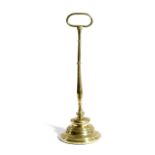 A VICTORIAN BRASS DOORSTOP LATE 19TH CENTURY with an oval handle, above a slender baluster with a