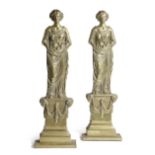 A PAIR OF VICTORIAN BRASS FIGURAL DOORSTOPS C.1870 in the form of a classical maiden holding fruit