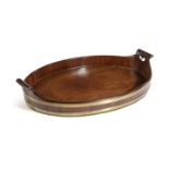 A GEORGE III MAHOGANY AND BRASS BOUND TRAY C.1780 of oval form, with heart shaped piercing to the