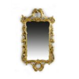 A GEORGE III GILTWOOD WALL MIRROR C.1770 the shaped rectangular plate in a frame with rocaille 'C'