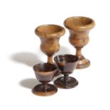 TWO GEORGE III TREEN BURRWOOD EGG CUPS LATE 18TH CENTURY of urn form with beaded decoration to the