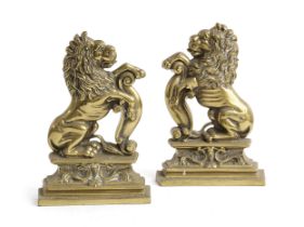A PAIR OF VICTORIAN BRASS RAMPANT LION DOORSTOPS C.1870 facing left and right, with their front paws