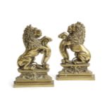 A PAIR OF VICTORIAN BRASS RAMPANT LION DOORSTOPS C.1870 facing left and right, with their front paws
