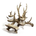 A VICTORIAN DEER ANTLER INKWELL AND PEN REST LATE 19TH CENTURY with two glass inkwells 26cm high,