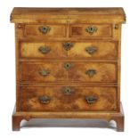 A GEORGE II WALNUT BACHELOR'S CHEST C.1735 crossbanded and inlaid with stringing, the quarter
