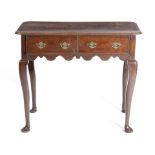 A GEORGE II OAK LOWBOY C.1730-40 the top with a moulded edge and rounded corners, above a pair of