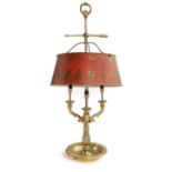 A FRENCH GILT BRASS BOUILLOTE LAMP IN LOUIS XVI STYLE with a loop handle and arrow, above a red
