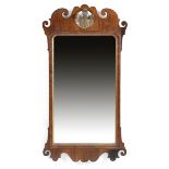 A GEORGE II WALNUT AND PARCEL GILT FRET-FRAME MIRROR C. 1730 the rectangular plate with a bevelled