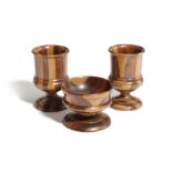A PAIR OF TREEN LABURNUM AND HOLLY URNS AND A MATCHING SALT SCOTTISH of footed form with turned