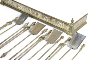 FOUR SETS OF BRASS FIRE IRONS 19TH CENTURY together with a pierced brass fire fender (13) 116.1cm