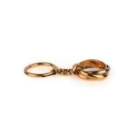 A gold keyring by Cartier, designed as three-colour gold interlocking bands suspending a plain