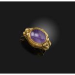 An amethyst cabochon silver gilt ring, set within a a fluted mounted with two birds beak to beak