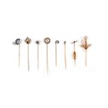 A group of eight stick pins, with finial designs including: a diamond cluster in a rope twist