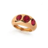 A spinel three stone ring, the three graduated oval-shaped red spinels set within rubover gold bombe