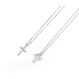 Two diamond cross pendant necklaces, one set with tapered baguette diamonds and centring on a