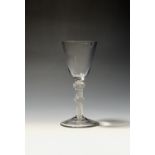 A wine glass c.1765, the rounded funnel bowl raised on a double-knopped multi series opaque twist