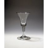 A large wine glass or goblet c.1750, the deep bell bowl raised on a thick airtwist stem above a