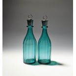 A pair of green glass decanters and stoppers 19th century, the bottle shaped bodies vertically