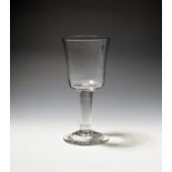 A glass goblet c.1750, the deep bucket bowl raised on a thick plain stem over a conical foot, 20.