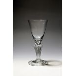 A large wine glass or goblet c.1735, the rounded funnel bowl with a solid base enclosing a tear,