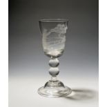 A glass goblet 19th century, the deep rounded funnel bowl engraved with a man with a gun aiming at a