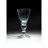 A heavy baluster goblet c.1710, the generous round funnel bowl raised on a baluster stem with two