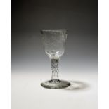A large wine glass or goblet c.1770, the round funnel bowl engraved with a long flowering branch and