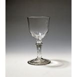 A glass goblet c.1770, the rounded bowl cut with seven petals around the base, above a knopped