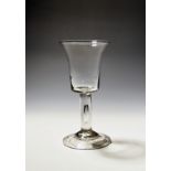 A large wine glass or goblet c.1750, the generous bucket bowl raised on a plain stem enclosing a