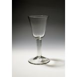 A large glass goblet c.1750, the generous round funnel bowl raised on a thick plain stem above a
