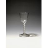 A wine glass c.1750, the ogee bowl with moulded flutes around the base, raised on an airtwist stem