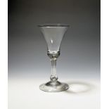 A large wine glass or goblet c.1740, the bell bowl raised on a baluster stem enclosing a long