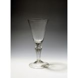 A large glass goblet c.1740, the deep rounded funnel bowl raised on an eight-sided pedestal stem