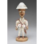 Thomas Ona. A Yoruba standing figure of an officer Nigeria with a detachable pith helmet, with a