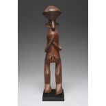 A Yaka standing female figure Nigeria with a lozenge coiffure, wide ears and grooved eyes, with