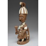 Thomas Ona. A Yoruba seated figure of an Oba Nigeria on a chair, wearing a detachable headdress with