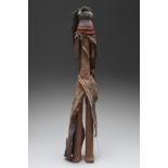 A Turkana doll Kenya with an applied fibre coiffure and wearing a bead neck piece and leather and