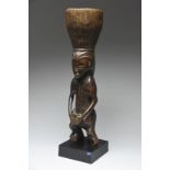 A Mbala figural mortar Democratic Republic of the Congo carved a standing drummer with a long