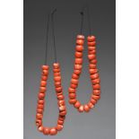 Two coral bead necklaces comprising fifty nine beads, the largest 2.2cm diameter. (2)